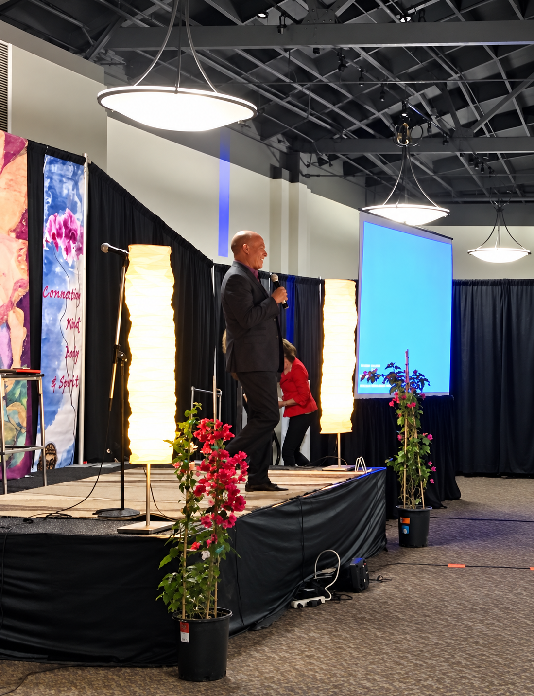 A speaker presenting on stage at a past New Living Expo