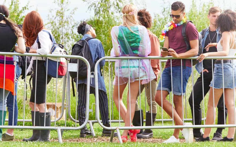 group-of-young-friends-waiting-behind-barrier-at-e-2023-11-27-04-50-03-utc.jpg